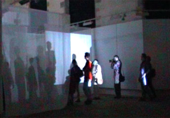 audience wandering around chapel - their shadows projected onto voile screens